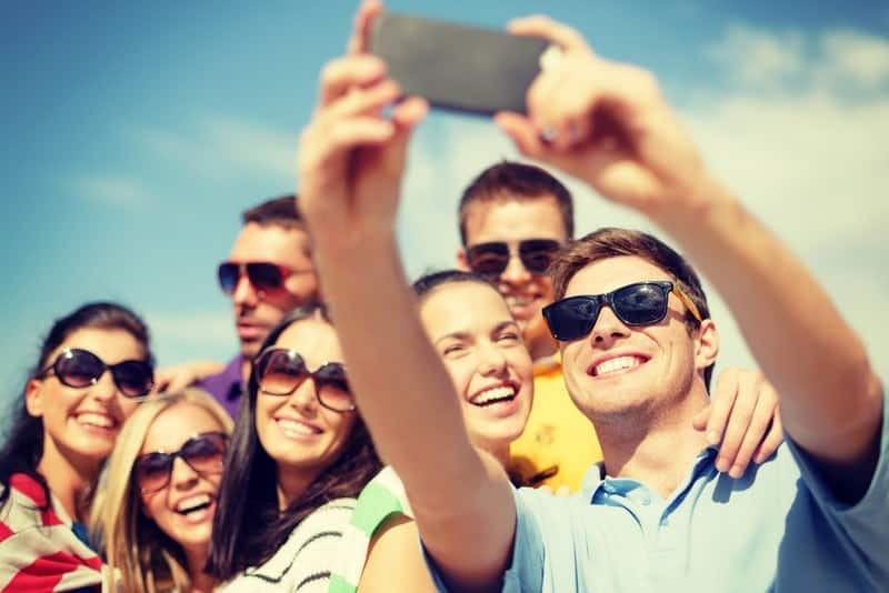 Group of smiling people takinf a selfie on vacation