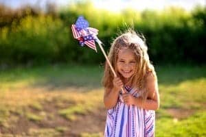 Little girl celebrating July 4th with an American flag pinwheel before the Pigeon Forge fireworks.