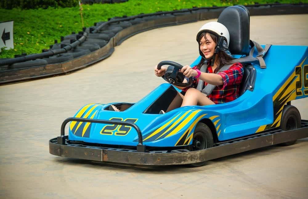 A young woman driving a go kart.
