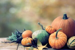 An arrangement of pumpkins and fall leaves.