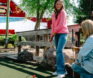 Two women are playing golf at Ripley’s Old MacDonald’s Farm Mini Golf