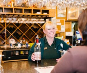 a woman with the bottle of wine at Apple Barn Winery