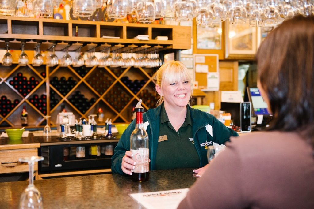 a woman with the bottle of wine at Apple Barn Winery