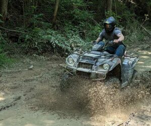 a person is riding ATV through the mud